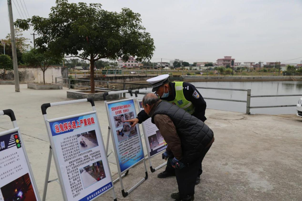 交警人员为社区居民讲解事故案例警示教育展板内容.png