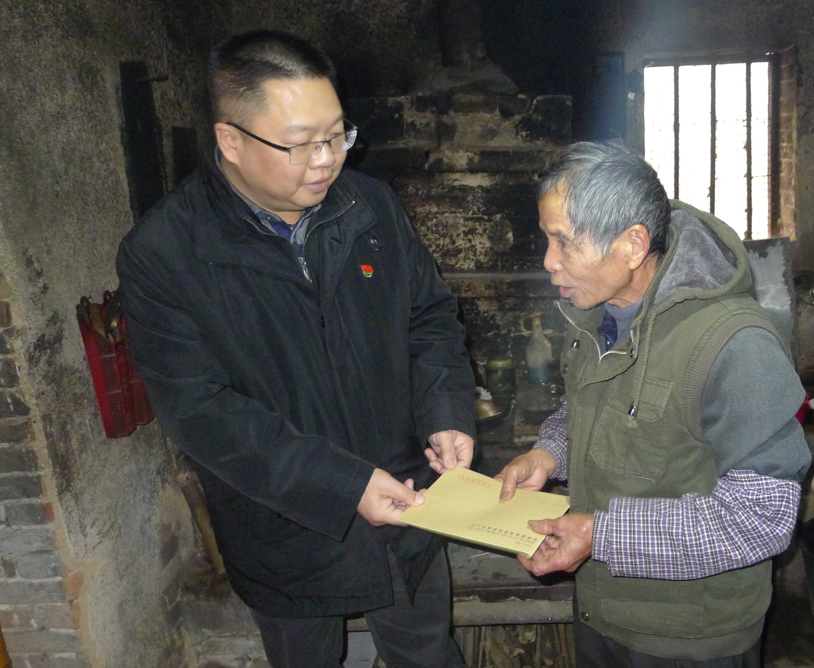 图为：江门市食品药品监督管理局党组成员、纪检组长蒋业洲向黄村村委会吴达文送上春节慰问.jpg