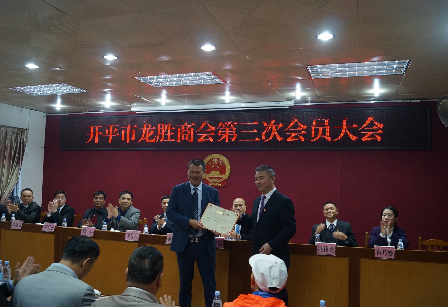 龙胜镇党委书记梁健忠为新一届商会会长张志明颁发证书.JPG